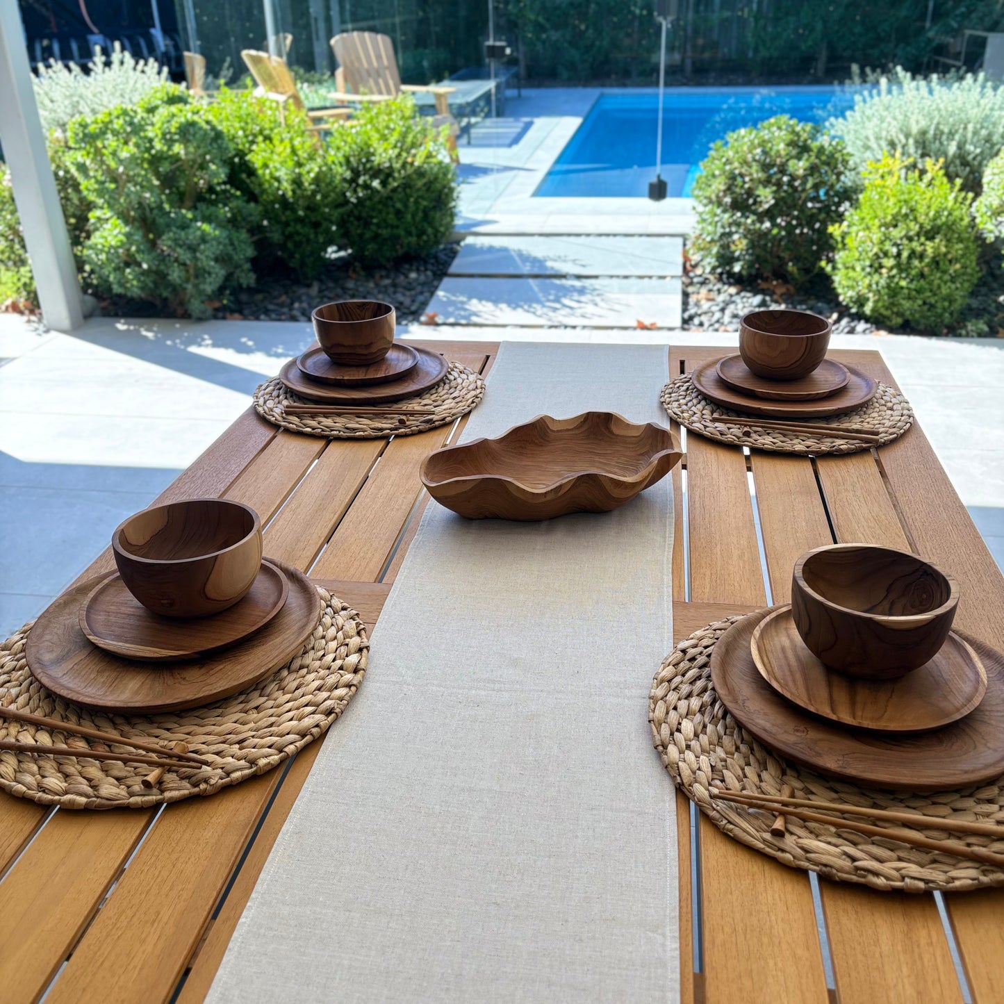 Image shows folded beige table runner on a set dining table. Hand-woven from 100% sustainable French linen, this table runner adds an earthy elegance and style to your dining table. Dimensions: 220cm x 30cm