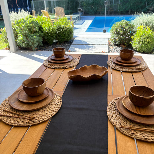 Image shows folded black table runner on a set dining table. Hand-woven from 100% sustainable French linen, this table runner adds an earthy elegance and style to your dining table. Dimensions: 220cm x 30cm