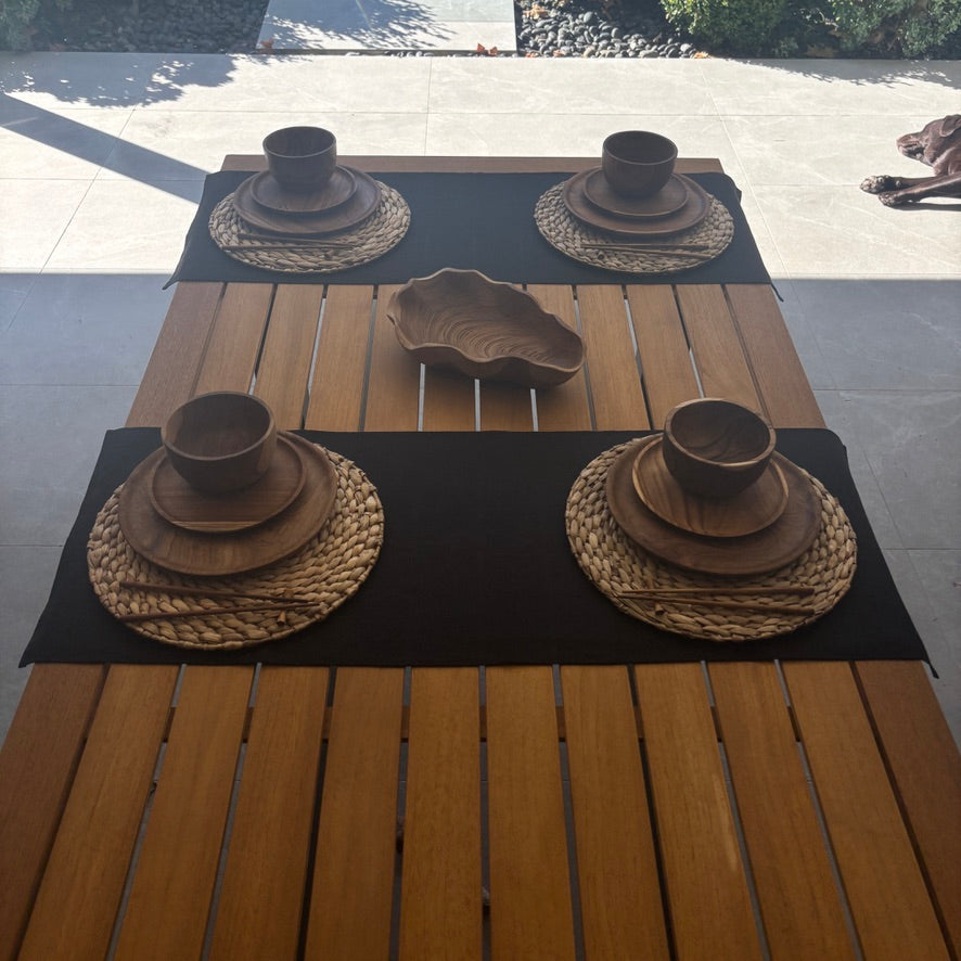 Image shows black table runner on a set dining table. Hand-woven from 100% sustainable French linen, this table runner adds an earthy elegance and style to your dining table. Dimensions - 110cm x 40cm