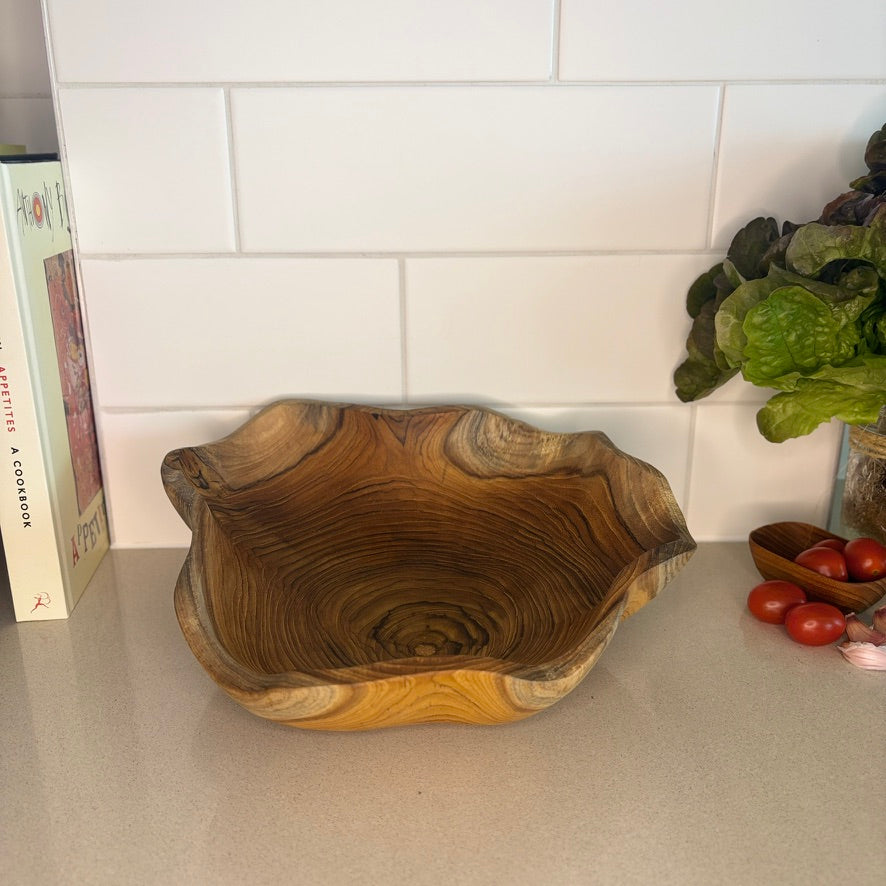A uniquely shaped bowl, hand-carved from sustainable teak root. Each bowl tells its own story through its intricate grain patterns and organic shape. Perfect for holding fruit, decorative accents, knick-knacks or standing alone as a statement piece. High quality, stylish and durable. Dimensions: 30cm x 25cm x 8cm