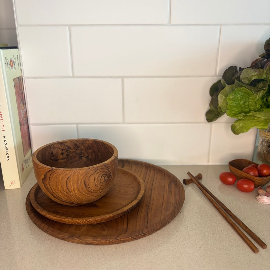 Images shows a stunning trio of handcrafted pieces, comprising a larger plate (28cm x 2cm), smaller plate (20cm x 1.5cm) and a bowl (14cm x 8cm). All pieces are handcrafted from sustainable teak and are as durable as they are stylish.