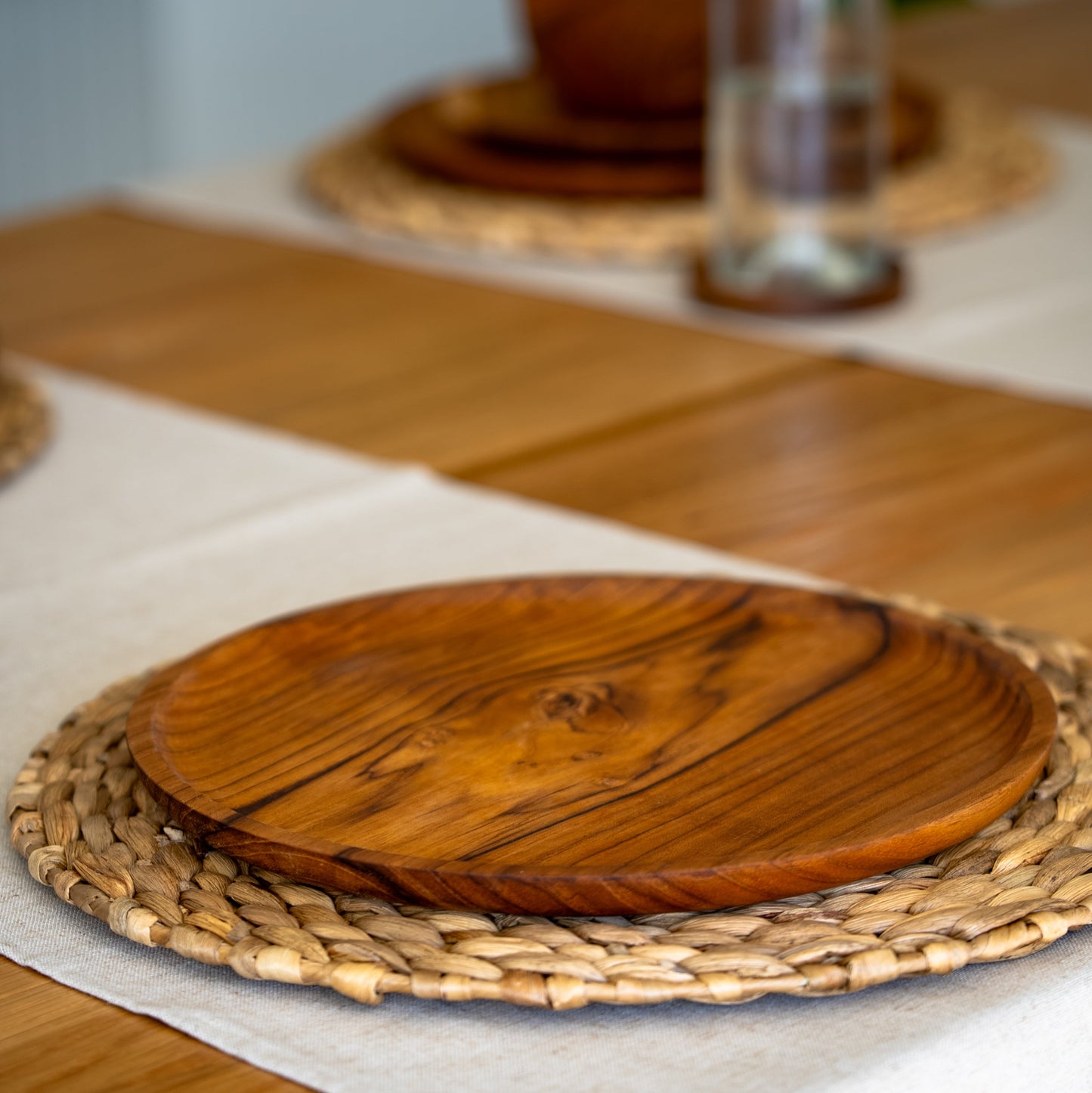 Images shows a stunning trio of handcrafted pieces, comprising a larger plate (28cm x 2cm), smaller plate (20cm x 1.5cm) and a bowl (14cm x 8cm). All pieces are handcrafted from sustainable teak and are as durable as they are stylish.