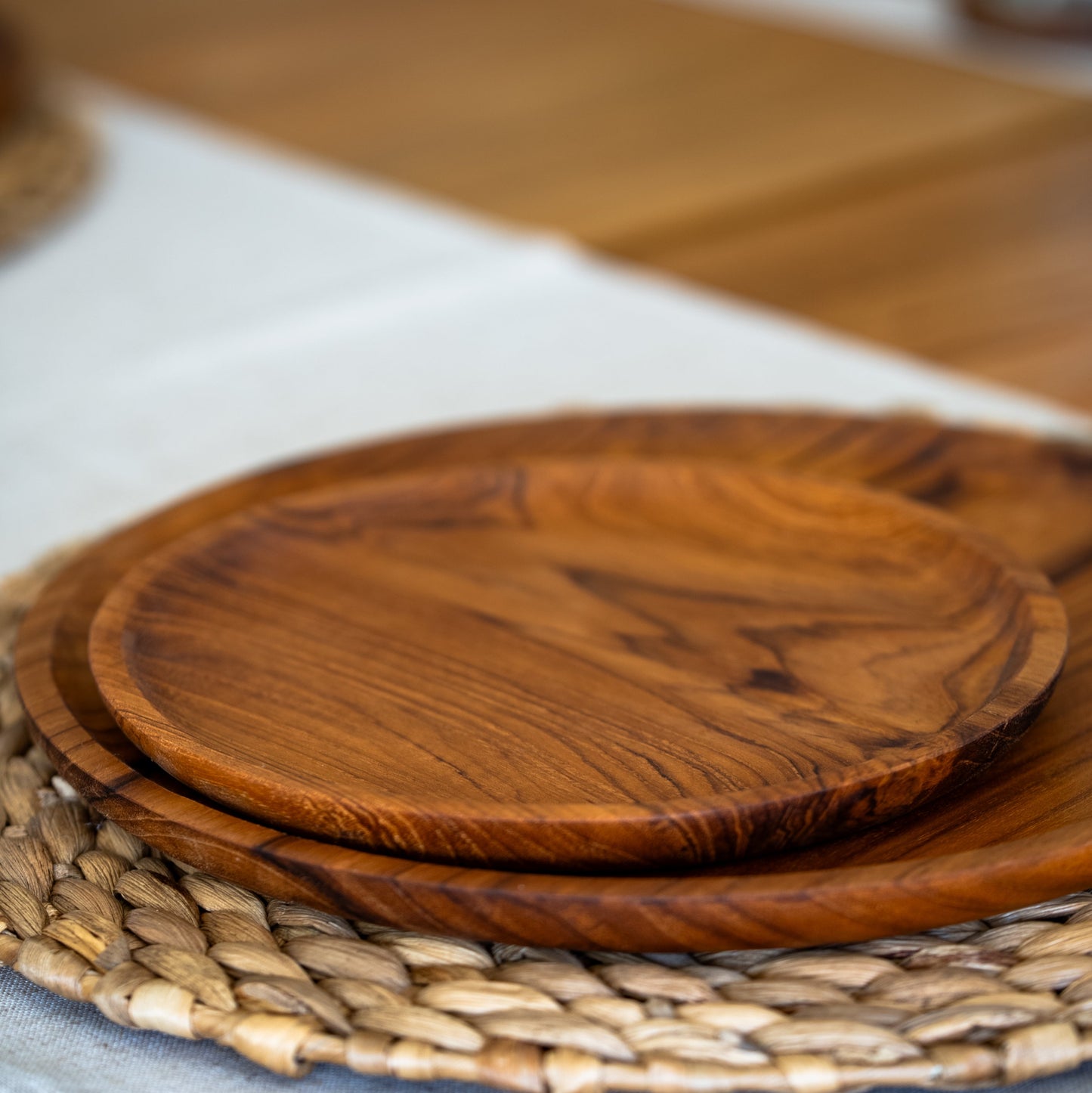 Images shows a stunning trio of handcrafted pieces, comprising a larger plate (28cm x 2cm), smaller plate (20cm x 1.5cm) and a bowl (14cm x 8cm). All pieces are handcrafted from sustainable teak and are as durable as they are stylish.