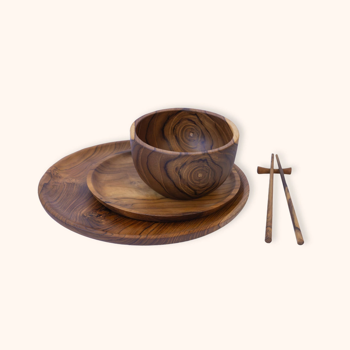 A dark brown teak wooden bowl with a matching saucer, on top of a larger plate and chopsticks resting on a holder, displayed on a solid cream background.