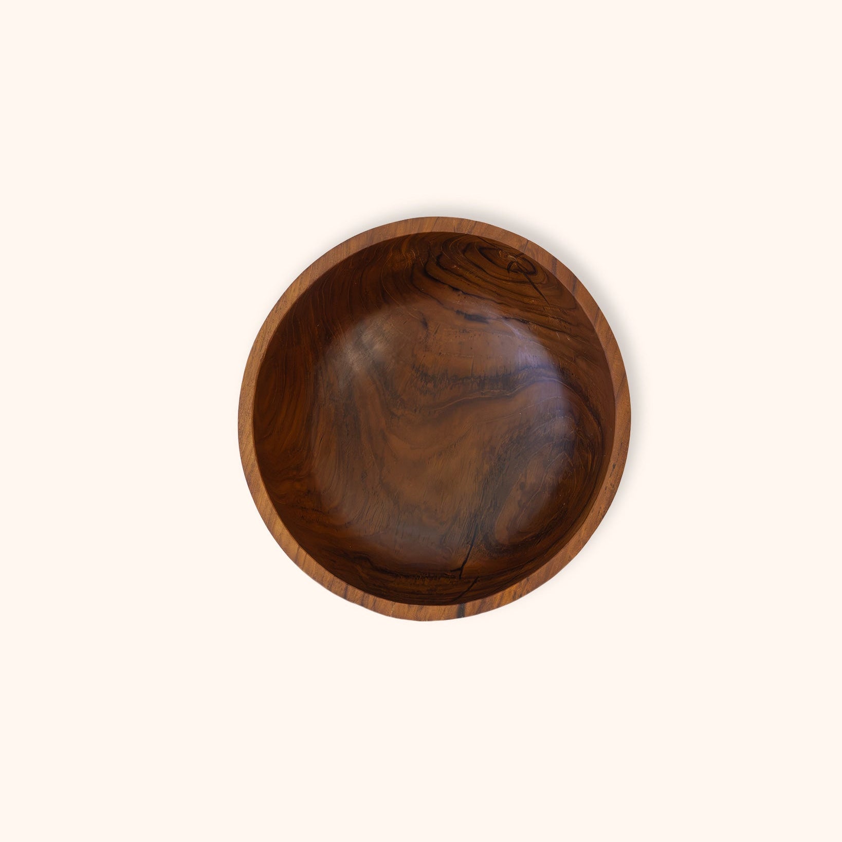 A round wooden bowl with a rich dark brown grain pattern, photographed from directly above on a solid off-white background.