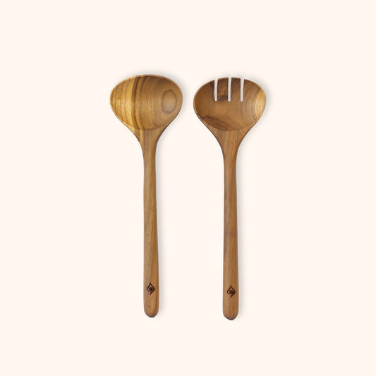 Two teak salad serving utensils, including a spoon and a slotted serving spoon, shown on a plain off-white background.