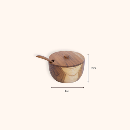 Teak salt keeper with spoon shown on a clean background with dimension arrows indicating 9 cm wide and 7 cm tall.