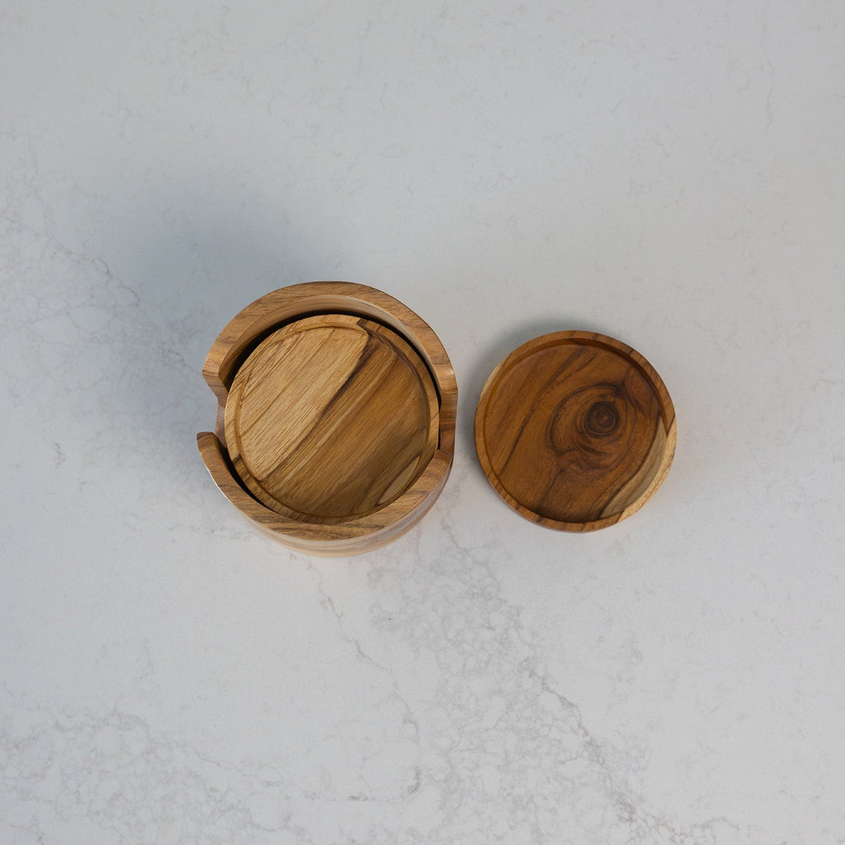 A round teak wooden coaster set with a natural wood grain pattern, shown from a top-down view on a marble bench
Coaster: 10cm x 1.5cm
Holder: 12cm x 10.5cm