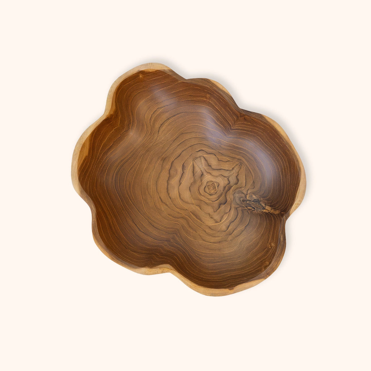 A handcrafted teak wooden bowl with a scalloped edge and a rich, swirling natural wood grain pattern, photographed from directly above on a solid off-white background.